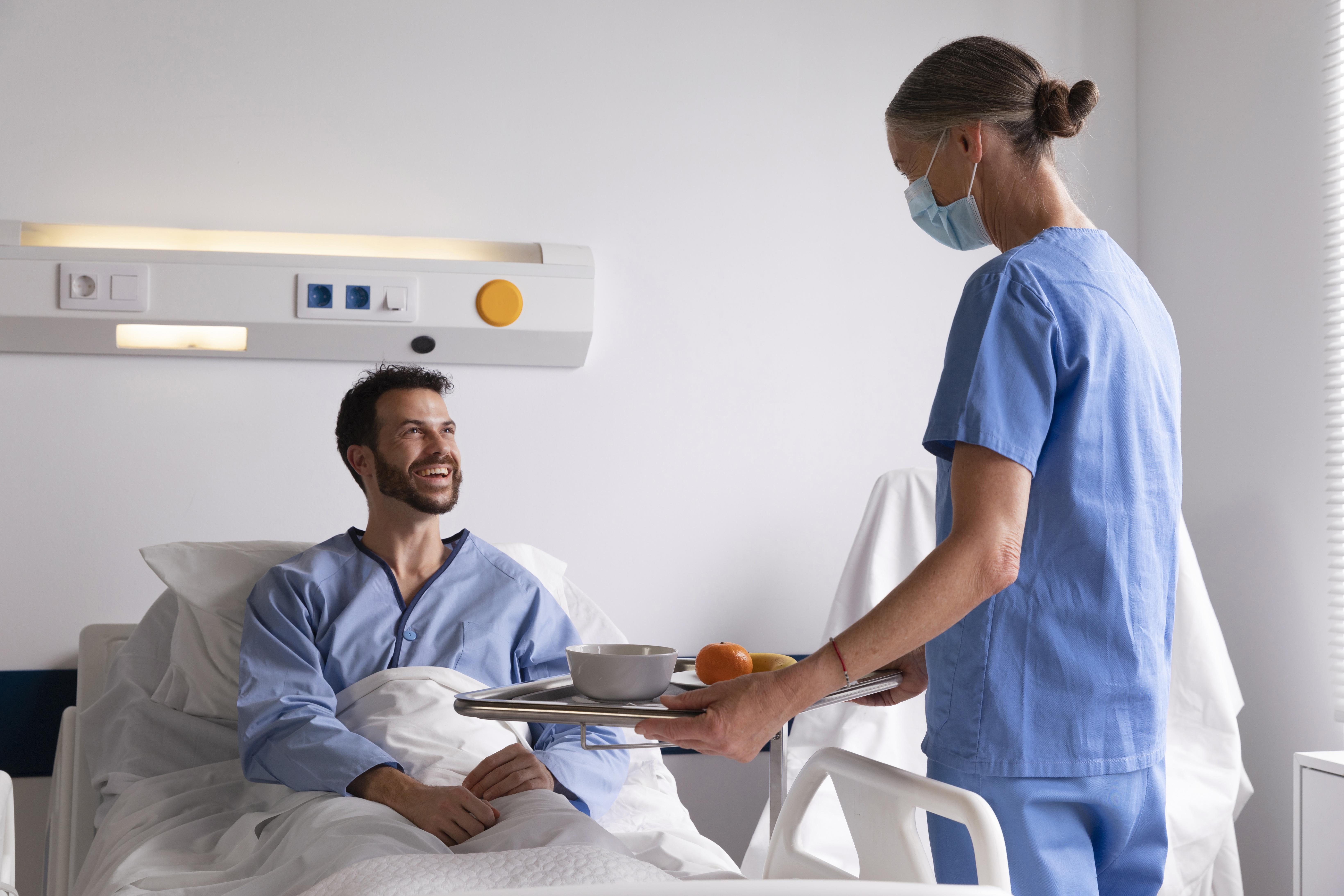 male-patient-in-bed-talking-to-nurse.jpg